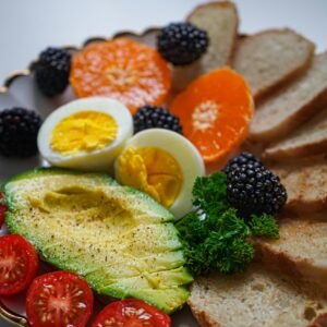 Vibrant breakfast plate with fresh avocado, eggs, and assorted fruits.