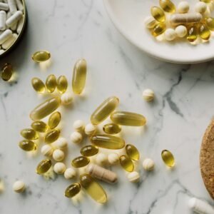 A collection of supplements and pills scattered on a marble surface, showcasing healthcare essentials.